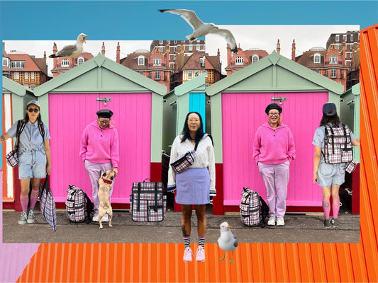 Bright beach huts with jacqui ma and tartan bags in front 