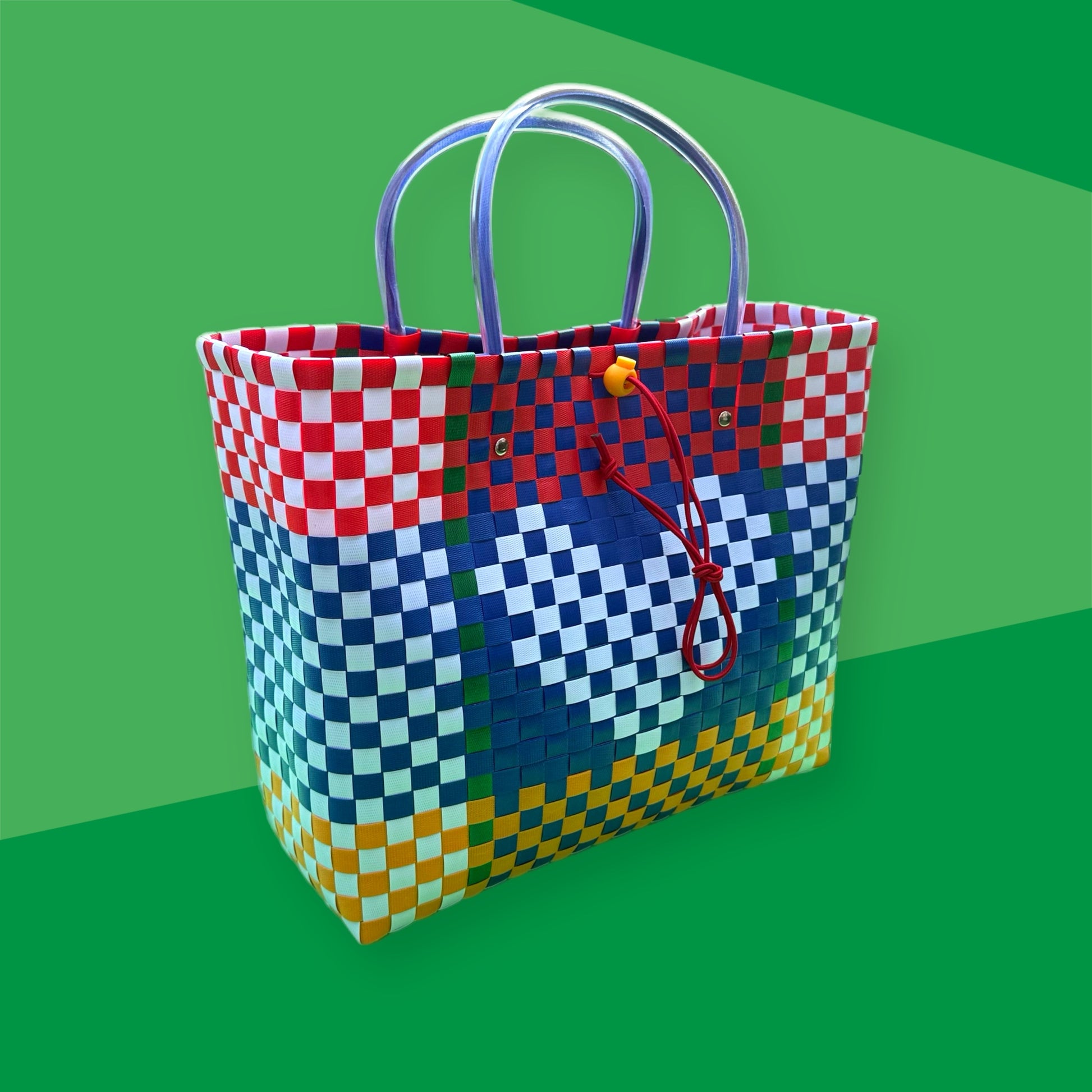 Colorful checkered bag with a red drawstring on a green background