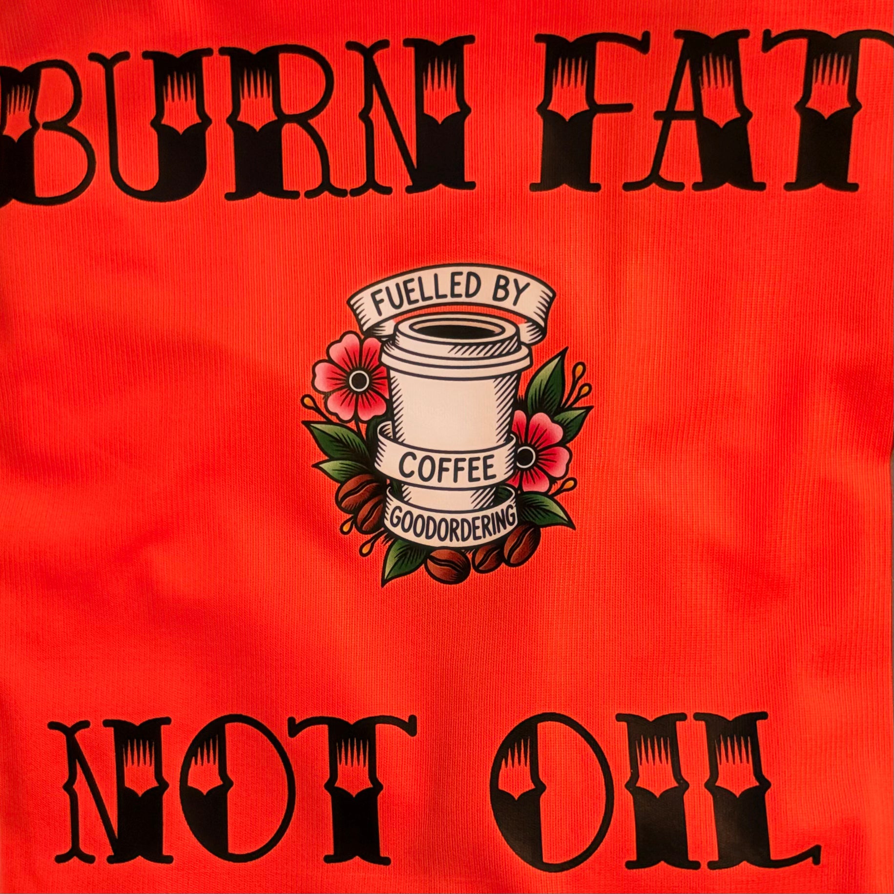 Customised cycling vest bright orange high vis fabric surface with black gothic-style text reading 'BURN FAT' at the top and 'NOT OIL' at the bottom, plus a central coffee cup illustration with flowers and the words 'FUELLED BY COFFEE GOODORDERING'.