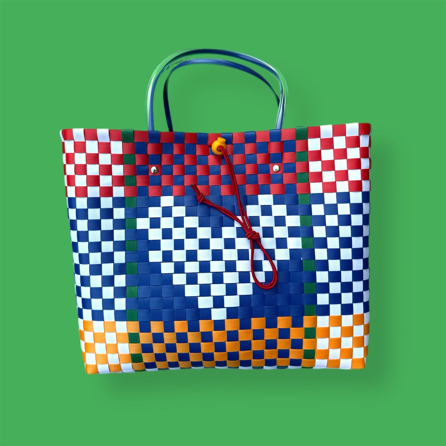 Colorful woven bag with a checkered pattern on a green background