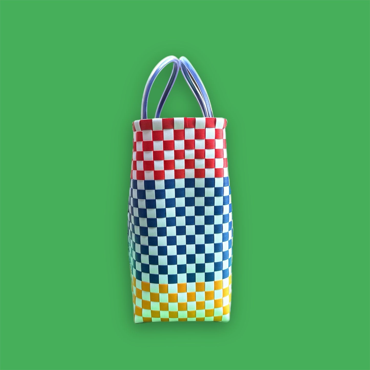 Colorful checkered bag with handles on a green background